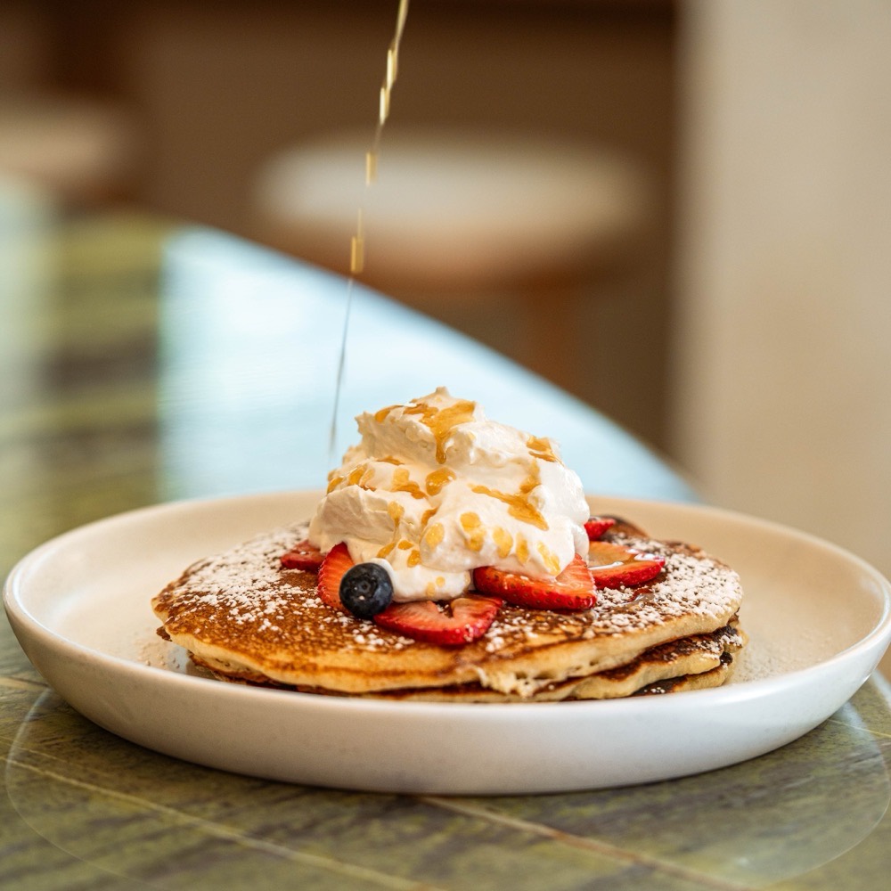 Stack of buttermilk pancakes with seasonal berries, a Café Maud brunch favorite